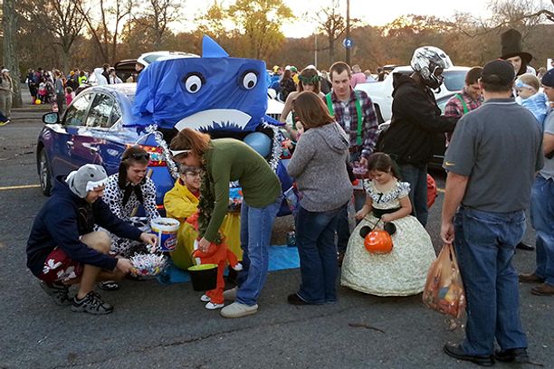 Kids dressed up and getting candy at Trunk or Treat