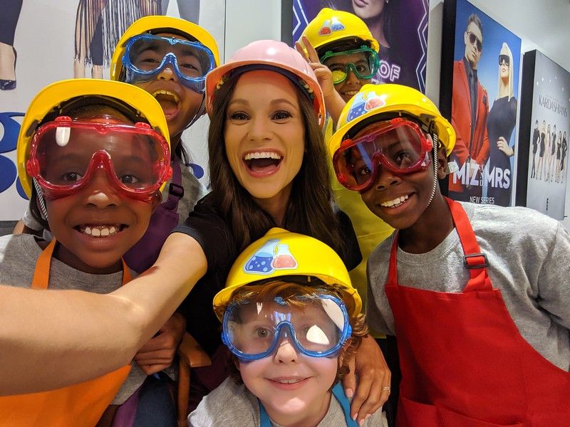 Emily posing with kids ready to work on STEM projects